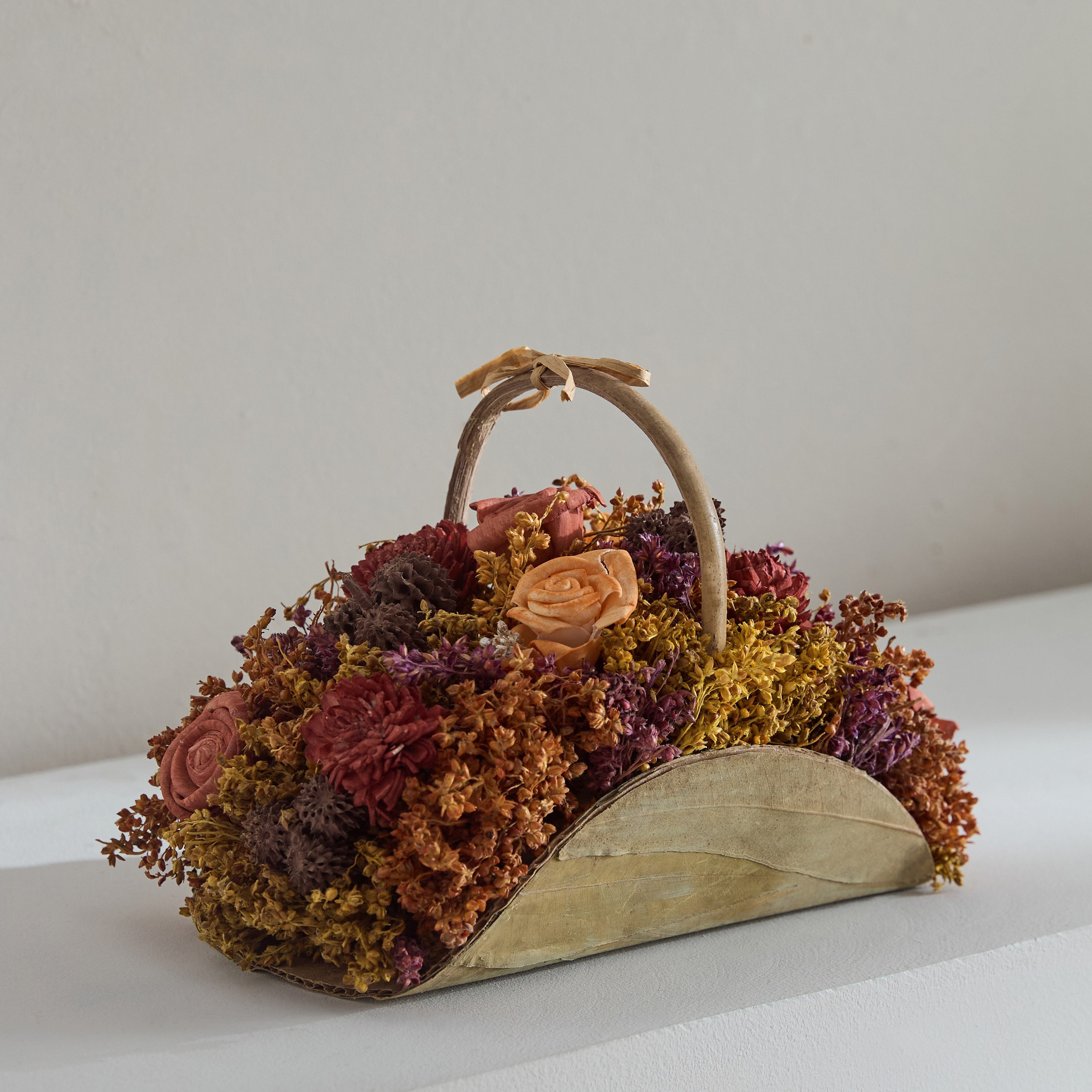 باقة من نبات شولا في سلة بمقبض من كيفن- 21x12x14.5 سم-hbxdecorandfurnishings-homeaccessories-artificialflowersandplants-image-1